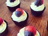 Red velvet cupcakes with chocolate dipped strawberry toppers