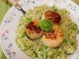 Seared scallops over pearl couscous with peas and garlic scape sauce