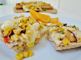 Open faced grilled cheese sandwich with roasted corn, plum and green chilies
