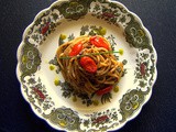 Spaghetti con patè di olive nere , datterini al forno e gocce di pesto di pistacchio